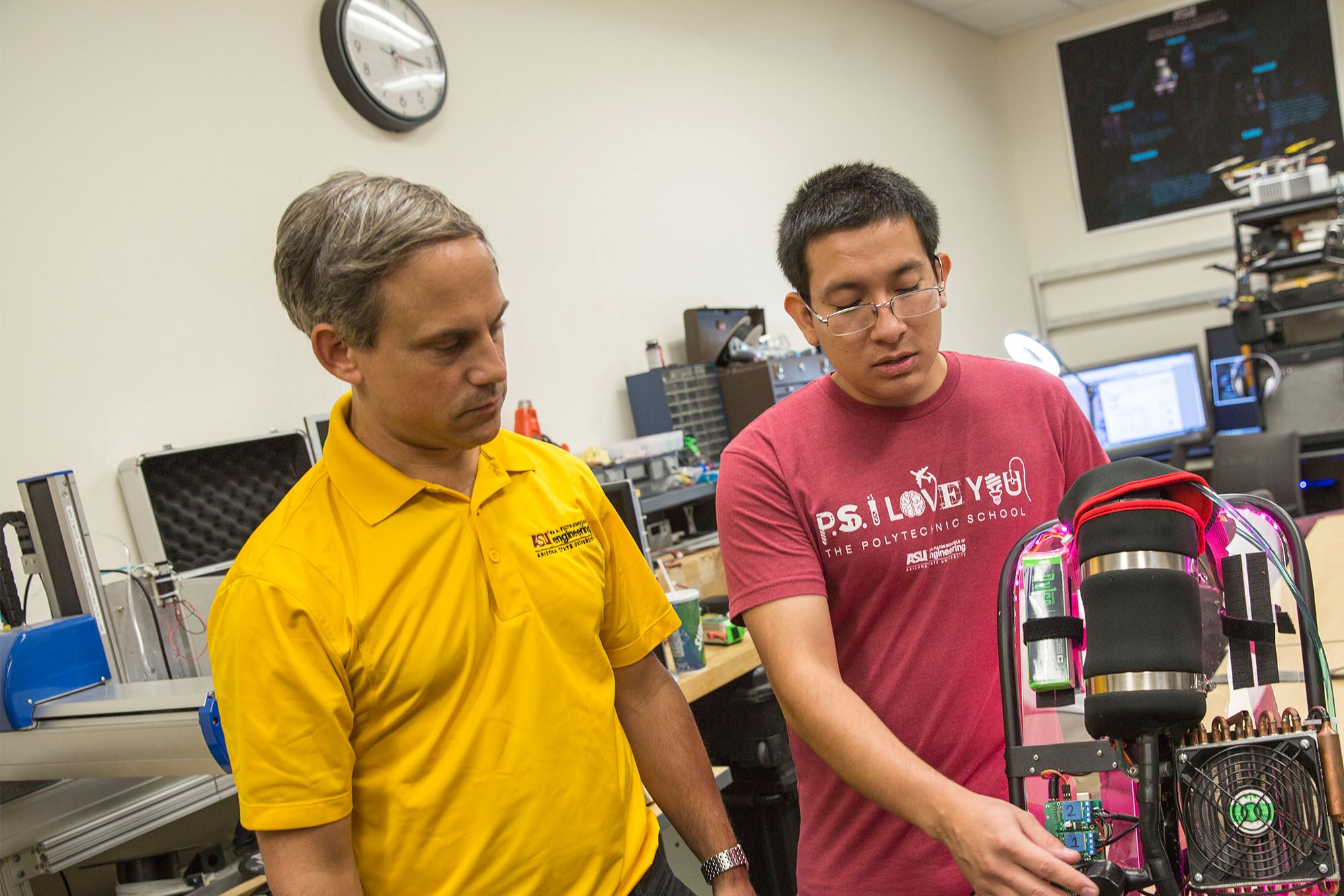 Tom Sugar works with a student on a wearable backpack-style device in his lab