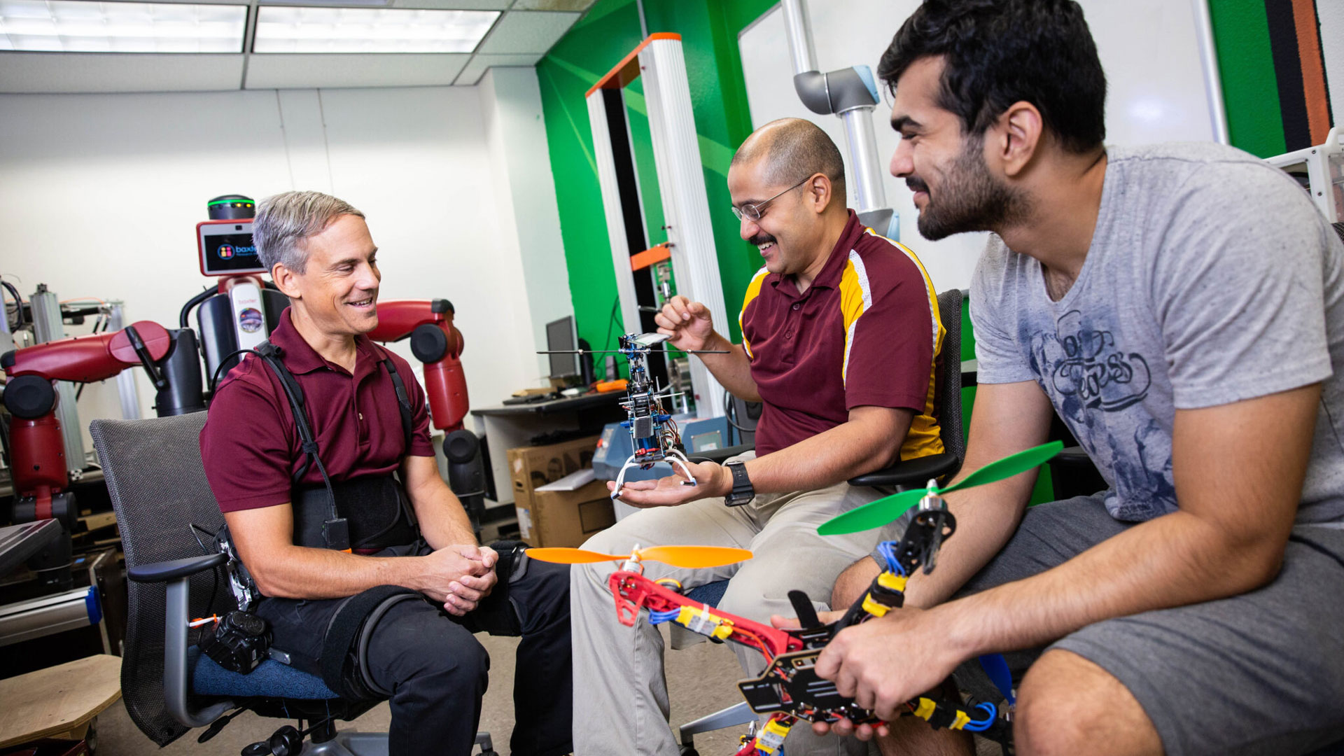 Thomas Sugar, President’s Professor of engineering in the Ira A. Fulton Schools of Engineering at Arizona State University, associate dean for Barrett, The Honors College at ASU’s Polytechnic campus and graduate program chair in the School of Manufacturing Systems and Networks, part of the Fulton Schools (left), and Sangram Redkar, professor of engineering in the Fulton Schools, associate director of the School of Manufacturing Systems and Networks and graduate program chair for robotics and autonomous systems (center), examine robotics projects with Fulton Schools systems engineering alumnus Sandesh Bhat (right). Photographer: Deanna Dent/ASU