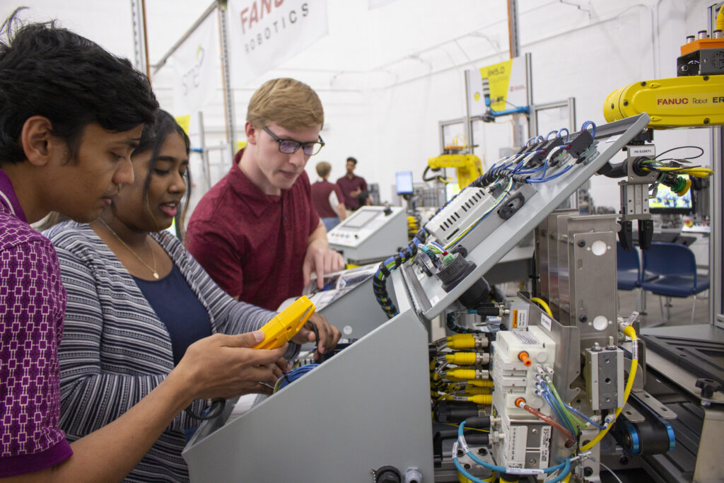 Students conversing in the Industrial Automation and Robotic Systems Laboratory.