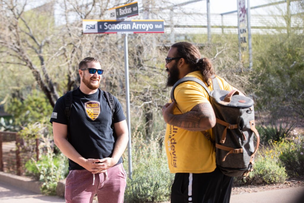 Two students have a conversation on the Polytechnic campus.