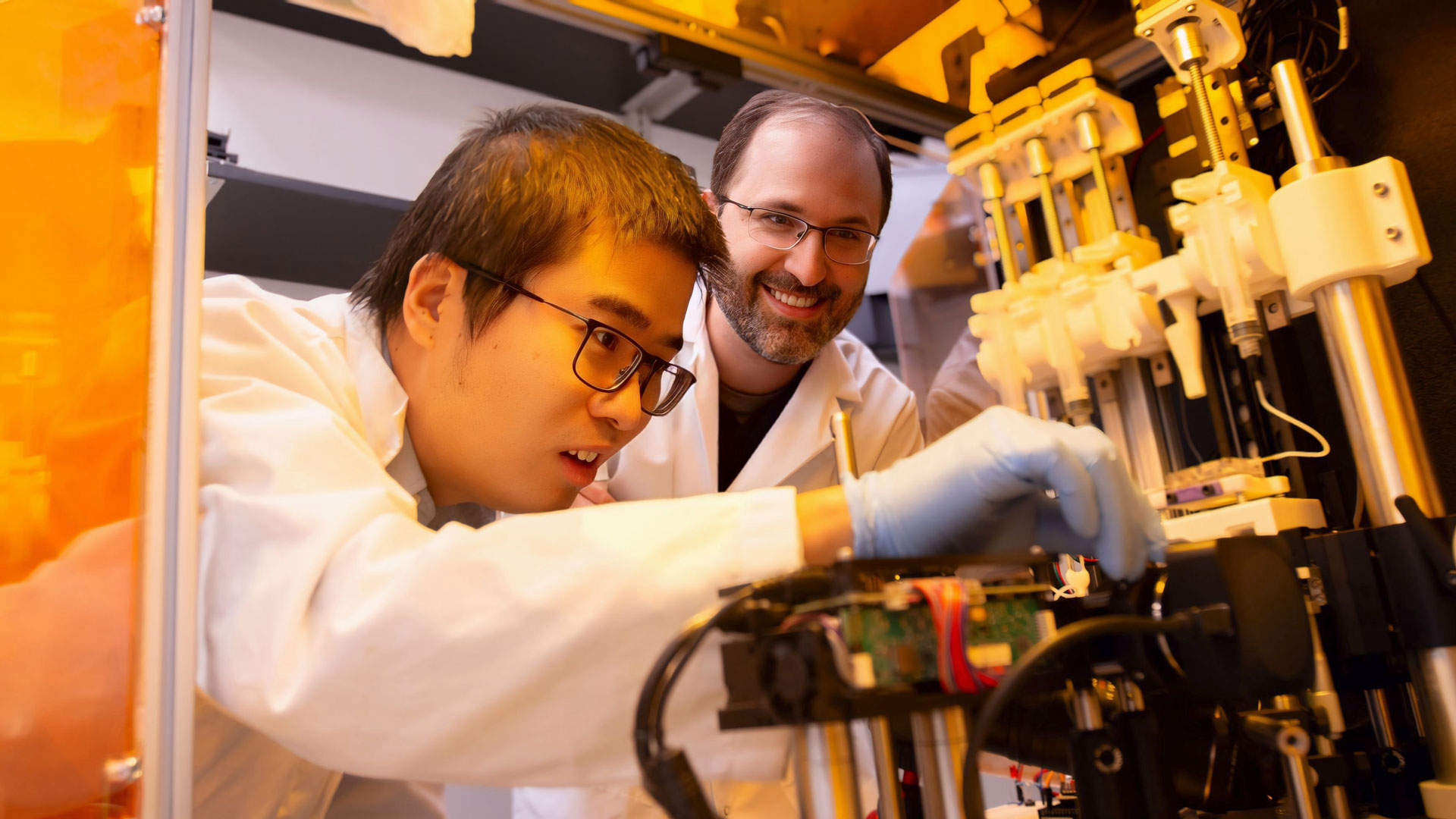Assistant Professor Xiangfan Chen (left) and Associate Professor Bruno Azeredo (right), manufacturing engineering faculty members in the School of Manufacturing Systems and Networks, part of the Ira A. Fulton Schools of Engineering at Arizona State University, are pictured observing a 3D printer in the Advanced Manufacturing and Functional Device Laboratory located in the Technology Center on the ASU Polytechnic campus. Photographer: Aisha Kaddi/ASU